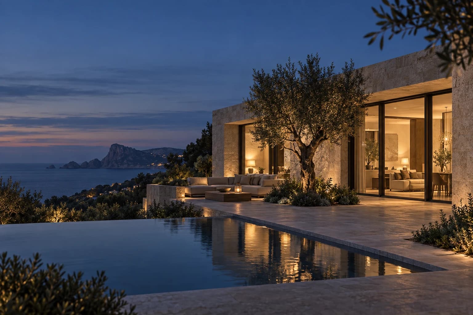 Mediterrane Villa bei blauer Stunde mit warmem Innenraum, Olivenbaum und Meerblick