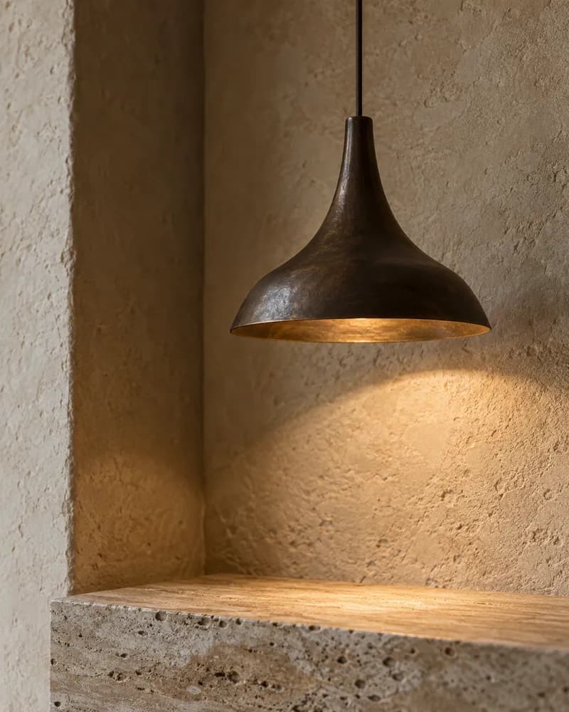 Bronzeleuchte mit warmem, kontrolliertem Licht auf mineralischer Wand