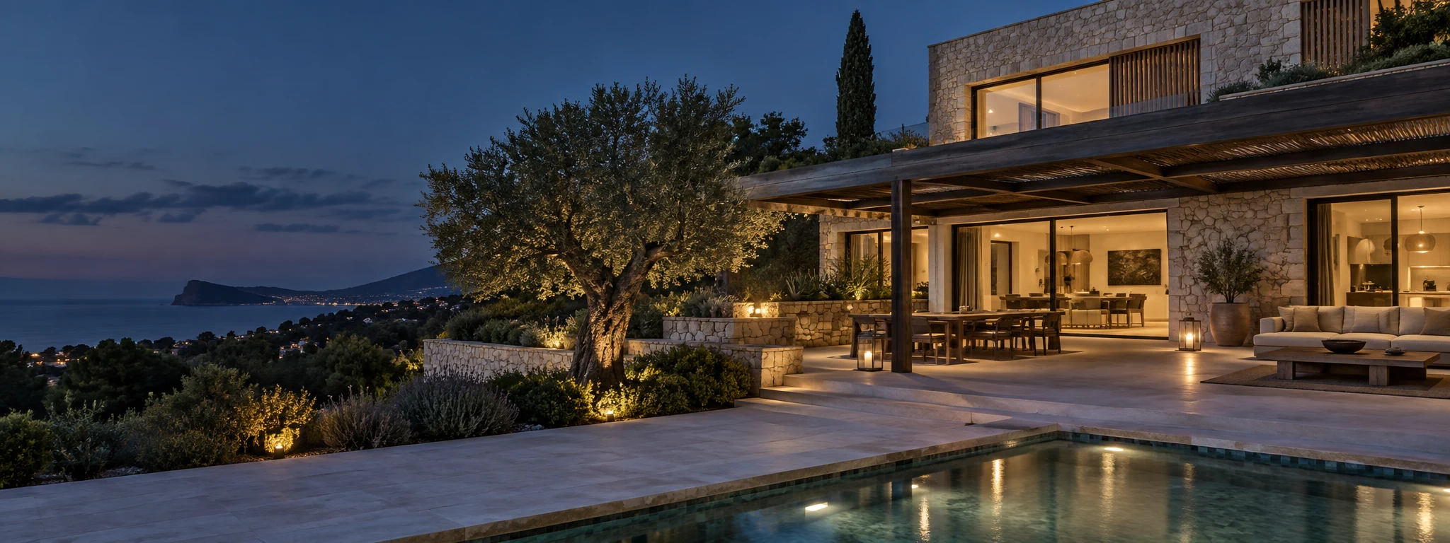 Gepflegte Villa mit Pool und warm beleuchteten Innenräumen in der blauen Stunde
